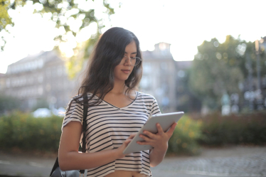 Photo by Andrea Piacquadio: https://www.pexels.com/photo/calm-pensive-female-freelancer-using-digital-tablet-on-street-3808773/